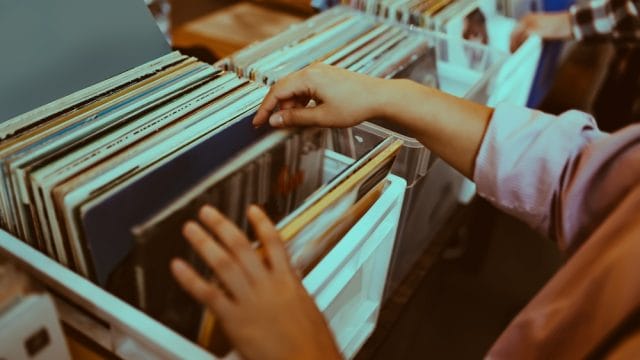 Woman is choosing a vinyl record in a musical store